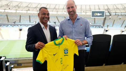 PA Media Cafu presenting a shirt to Prince William